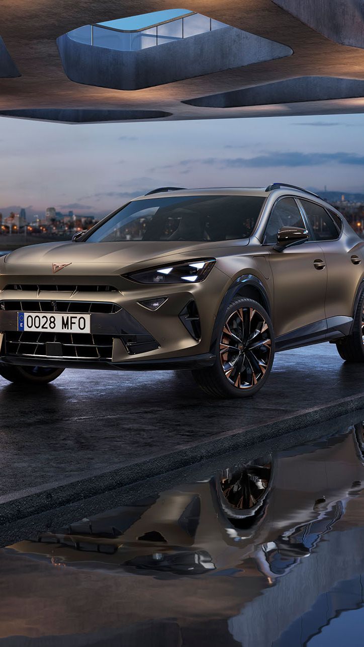 CUPRA Formentor 2025 SUV coupé junto a água refletora, sob construção de betão, com cidade crepuscular e arranha-céus iluminados.