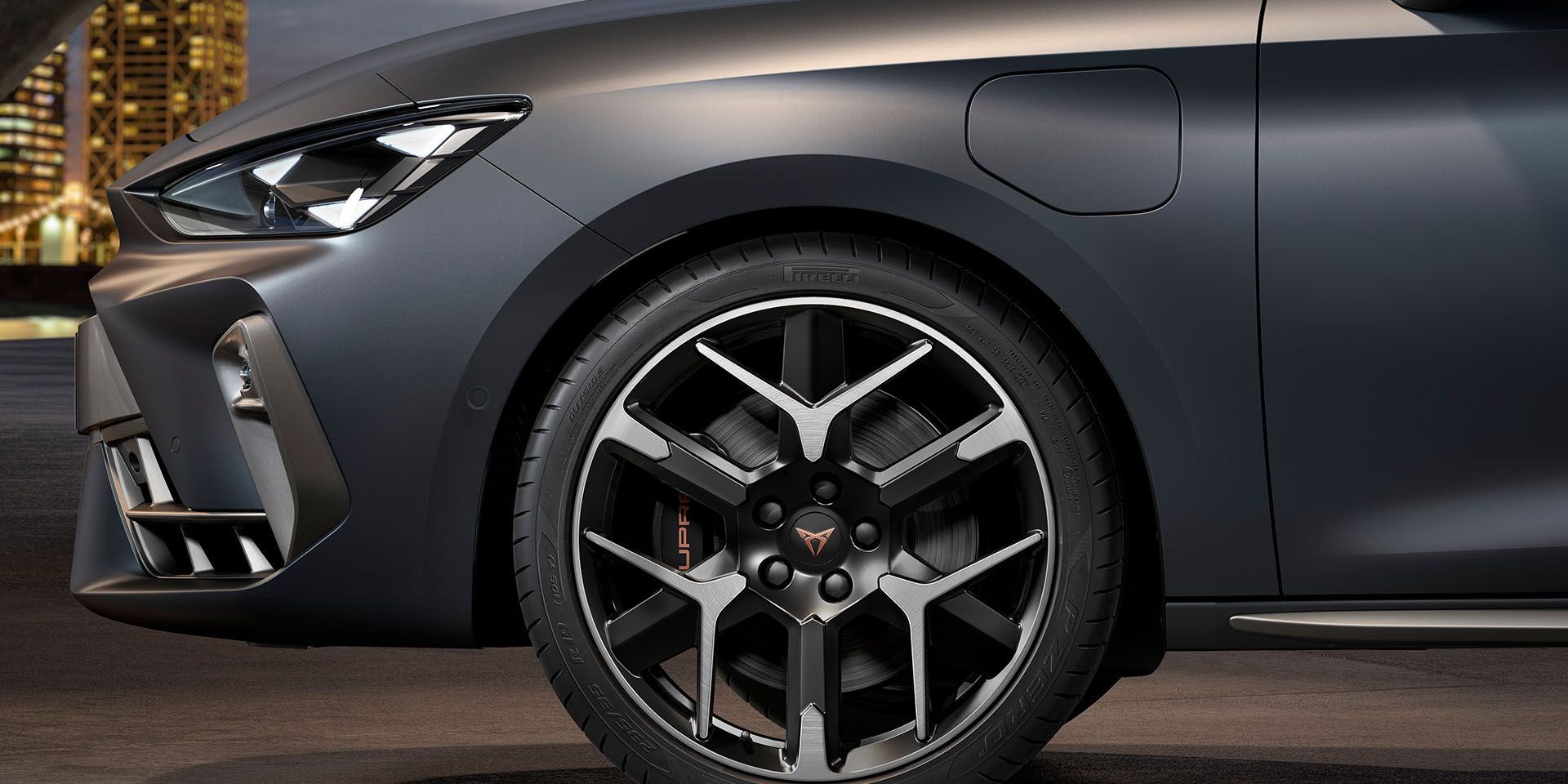 vista frontal da jante forjada em prata e preto para o novo cupra leon sportstourer 2024, pneus, assinatura dos faróis e carroçaria cinzenta