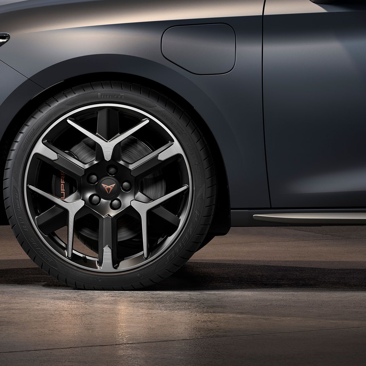 vista frontal da jante forjada em prata e preto para o novo cupra leon sportstourer 2024, pneus, assinatura dos faróis e carroçaria cinzenta