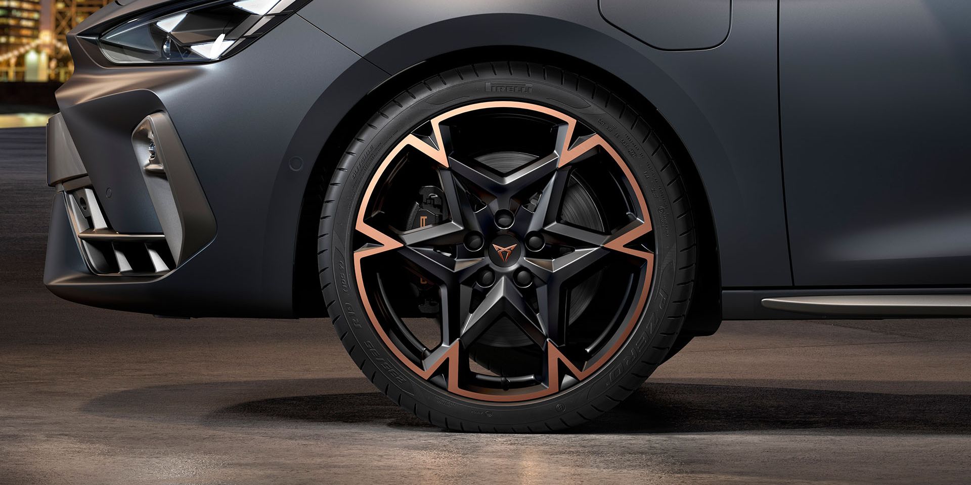 vista frontal das jantes de liga leve em preto e cobre para o novo cupra leon sportstourer 2024, pneus, assinatura dos faróis e carroçaria cinzenta