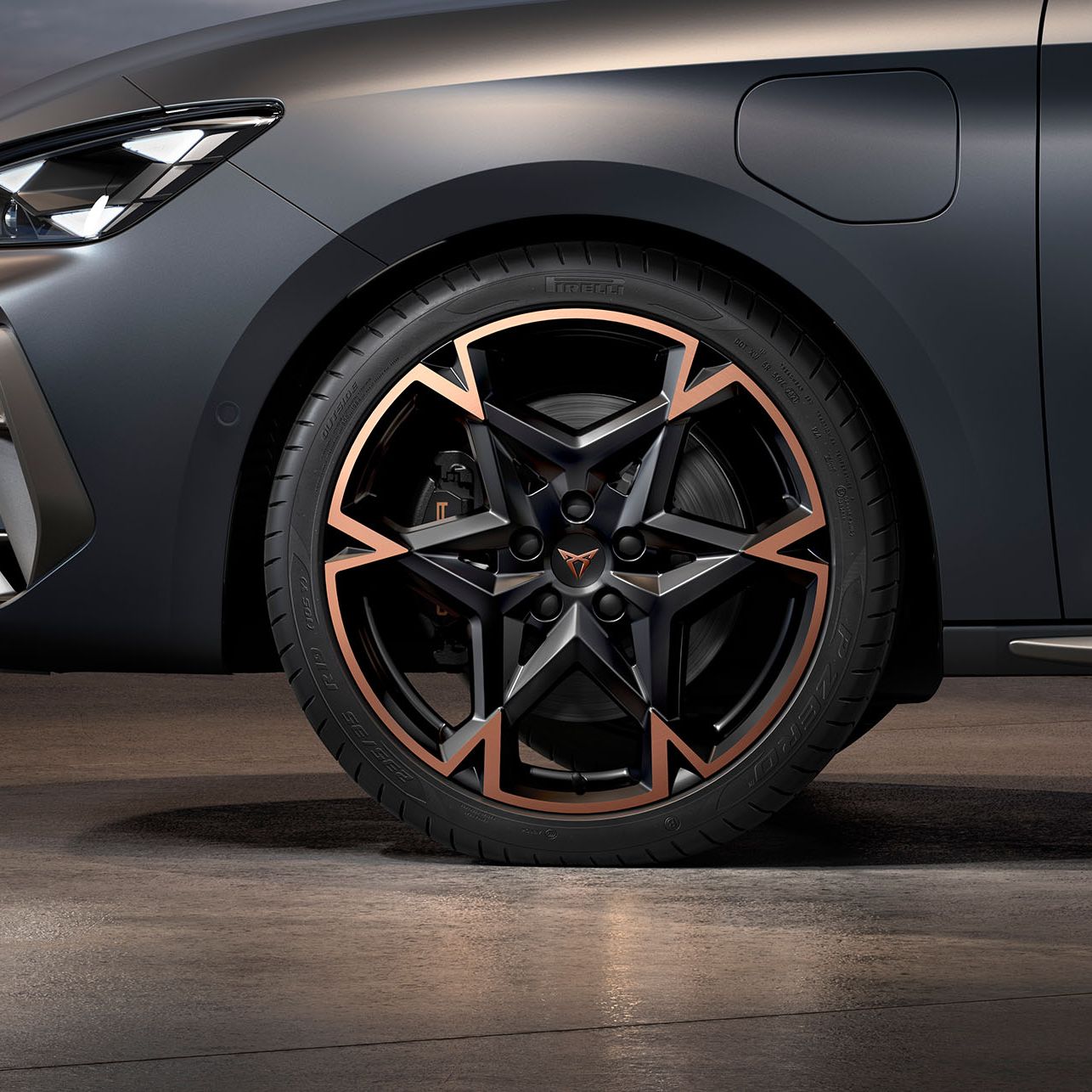vista frontal das jantes de liga leve em preto e cobre para o novo cupra leon sportstourer 2024, pneus, assinatura dos faróis e carroçaria cinzenta