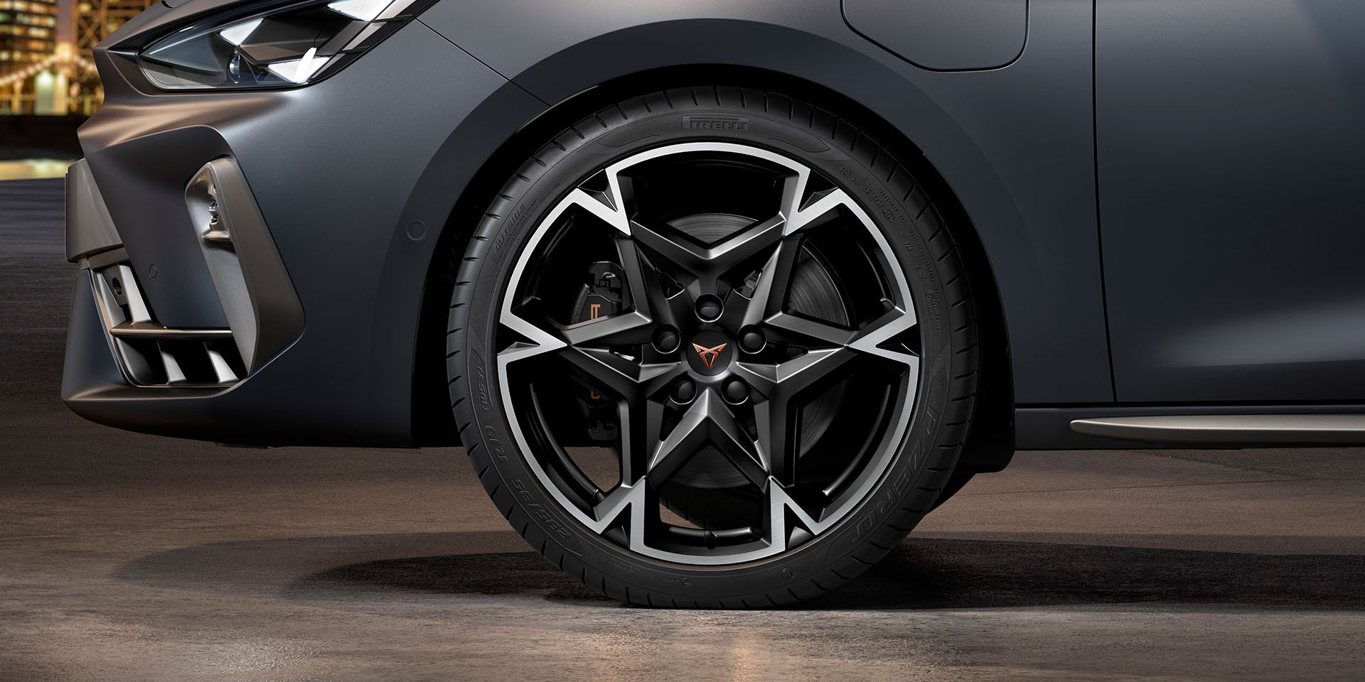vista frontal das jantes de liga leve polar maquinada em preto e prata para o novo cupra leon sportstourer, pneus, assinatura dos faróis e carroçaria cinzenta