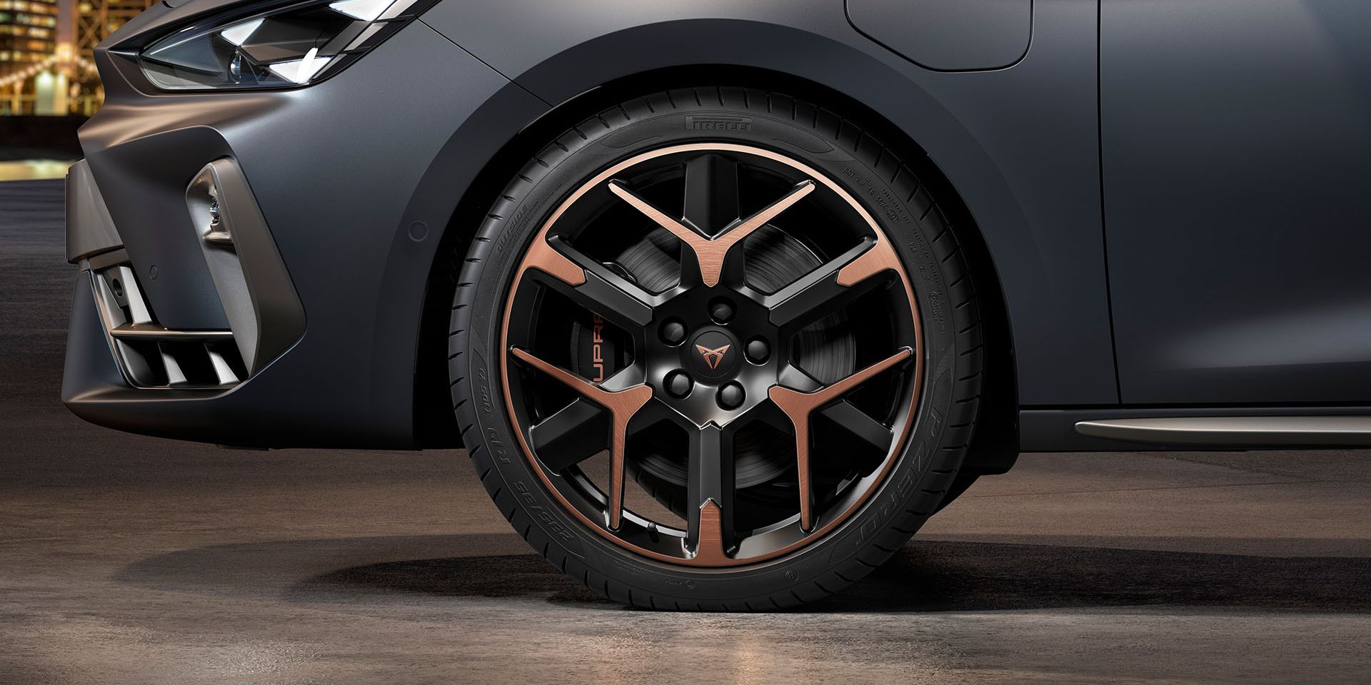 vista frontal da jante de liga leve forjada em cobre e preto para o novo cupra leon sportstourer 2024, pneus, assinatura dos faróis e carroçaria cinzenta
