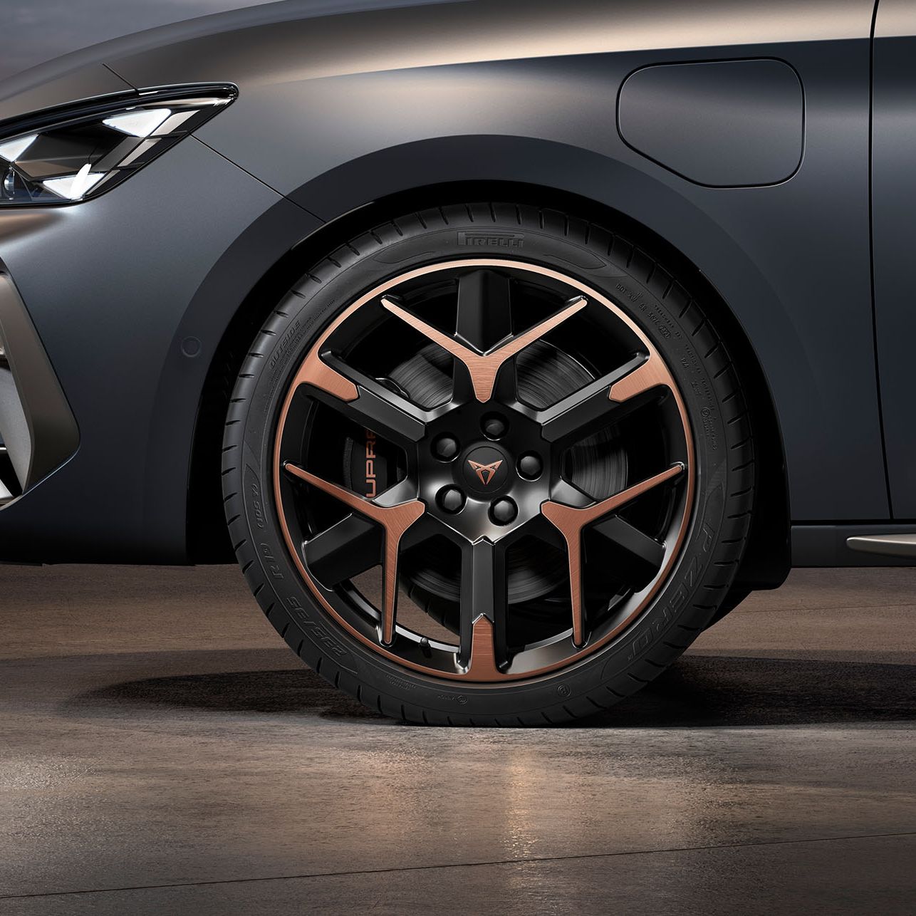 vista frontal da jante de liga leve forjada em cobre e preto para o novo cupra leon sportstourer 2024, pneus, assinatura dos faróis e carroçaria cinzenta
