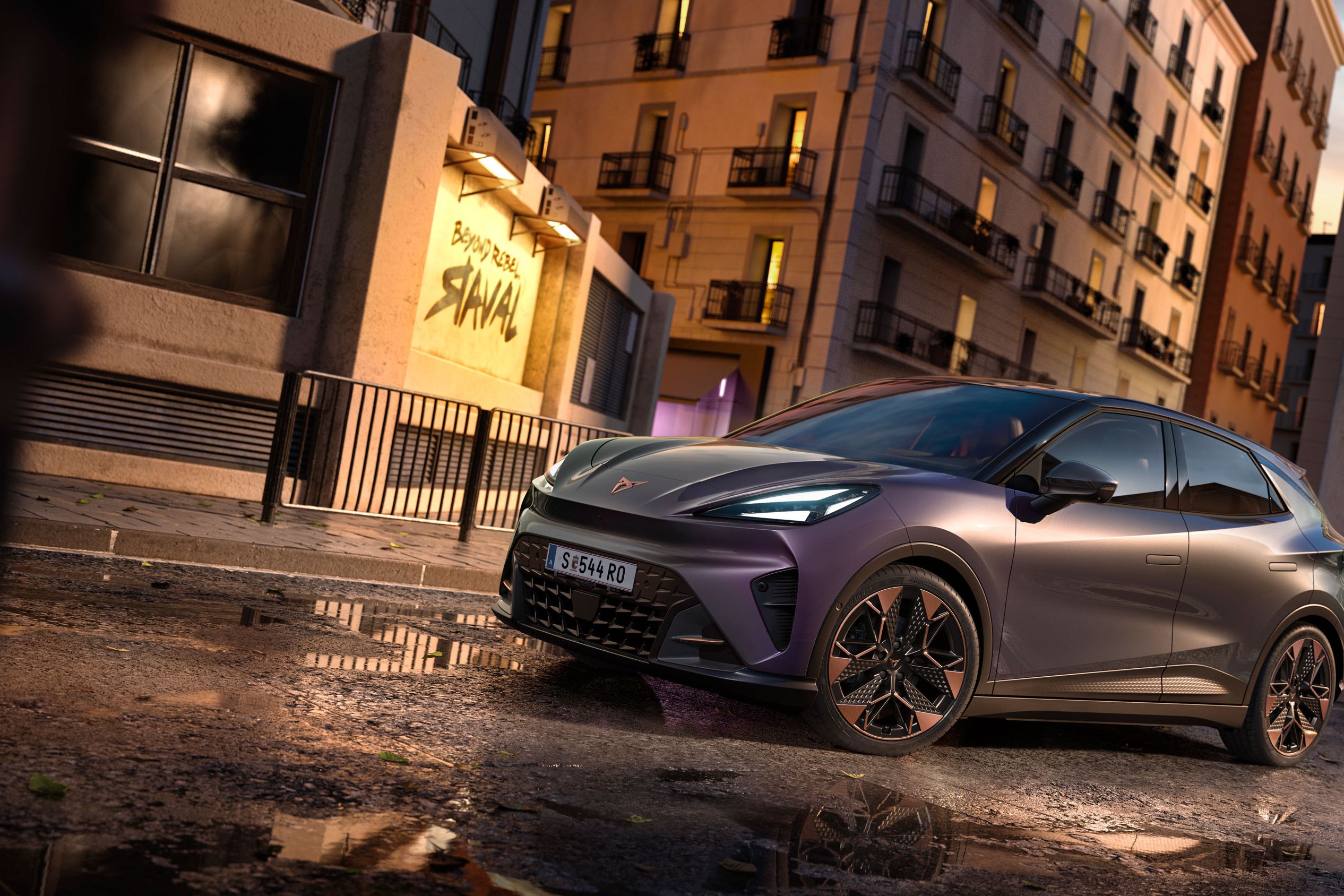 Plano aproximado do logótipo CUPRA, seguido de uma vista completa do CUPRA Raval VZ em cor plasma com jantes de 19 polegadas, estacionado num cenário urbano.