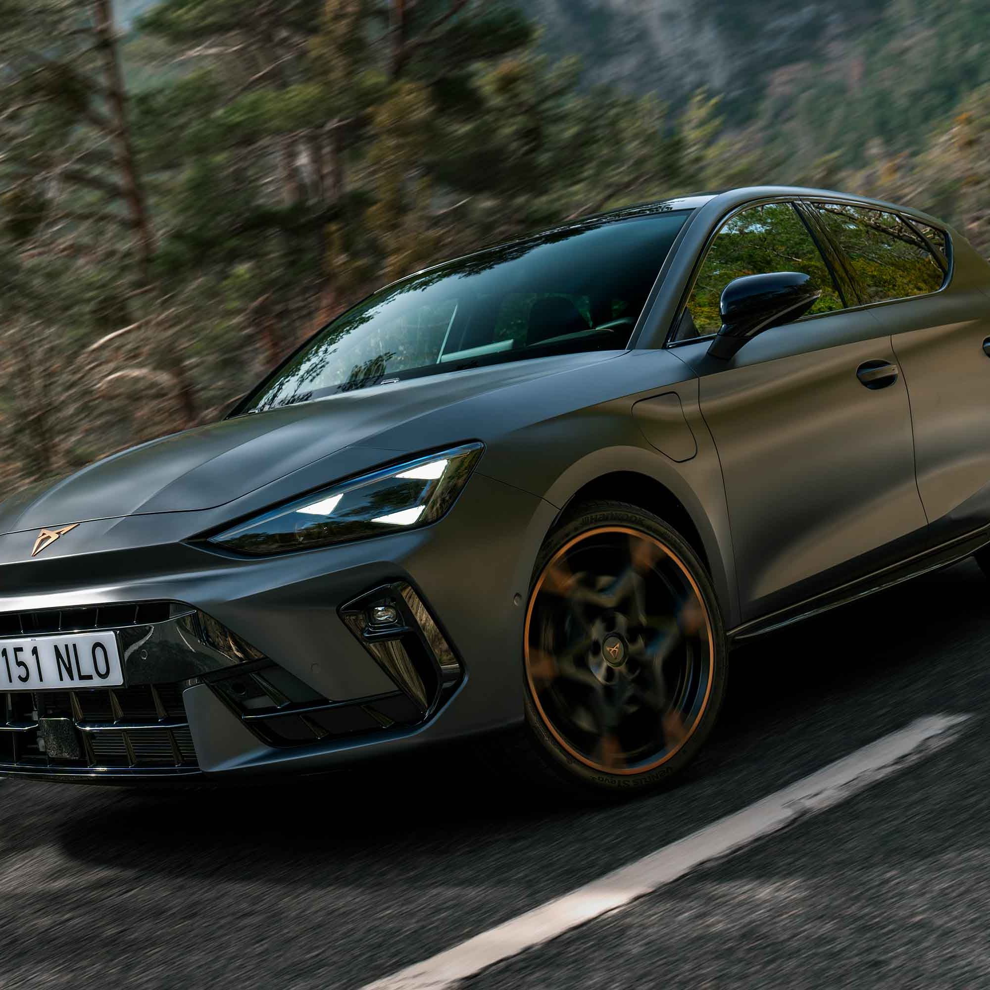 grande plano do novo CUPRA Leon[IC28.1], faróis e jantes forjadas de 19” com detalhes em cobre e carroçaria em cinzento enceladus mate