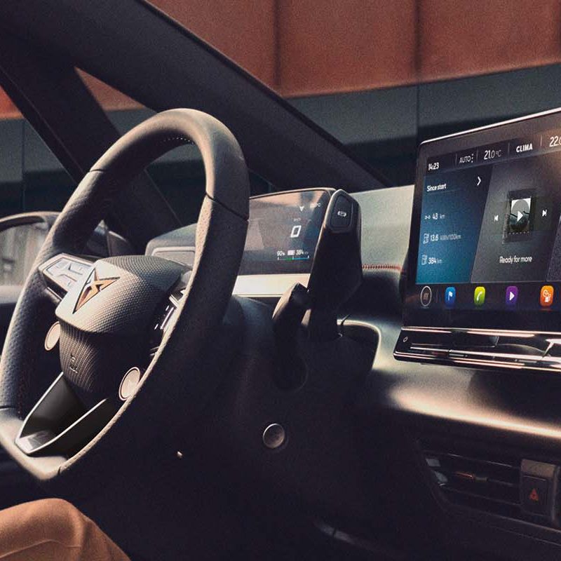 Mulher a ver as atualizações OTA do CUPRA no dispositivo de infoentretenimento do seu carro.