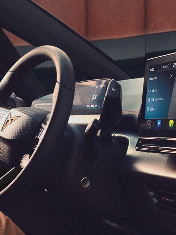 Mulher a ver as atualizações OTA do CUPRA no dispositivo de infoentretenimento do seu carro.