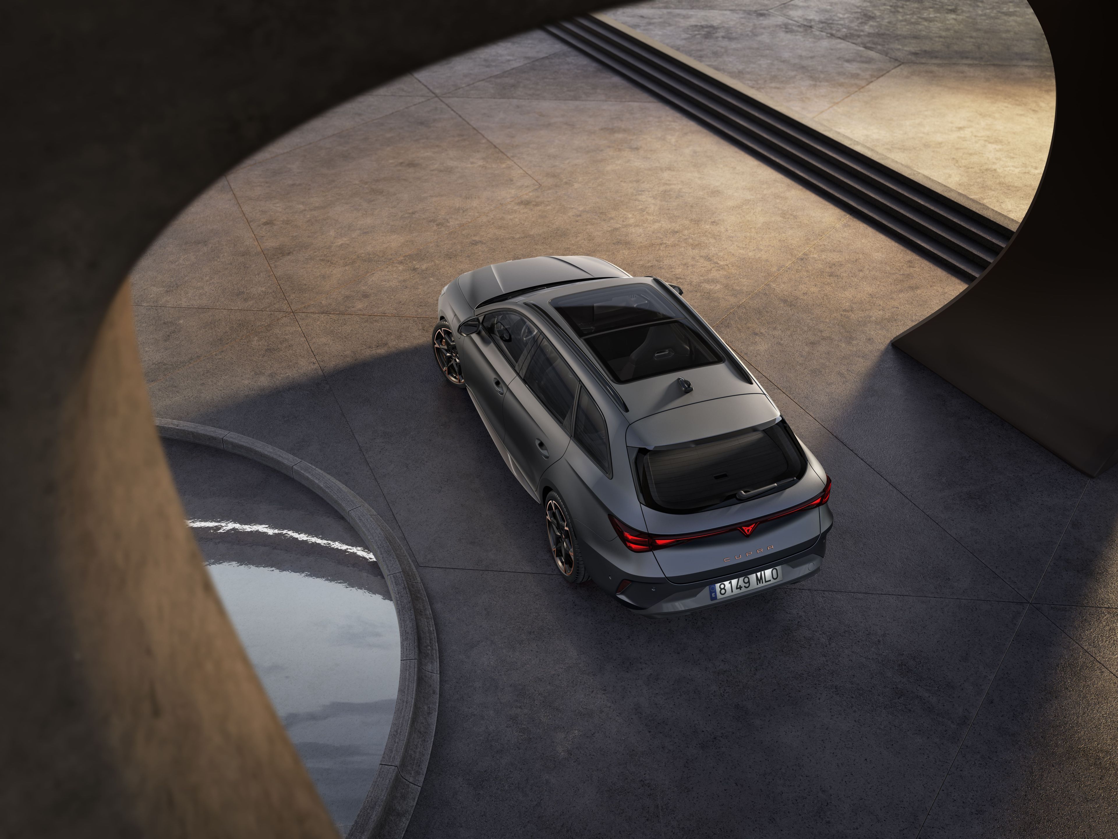 Vista aérea do novo cupra leon sportstourer híbrido cinzento, para-choques traseiro, luzes traseiras acesas.