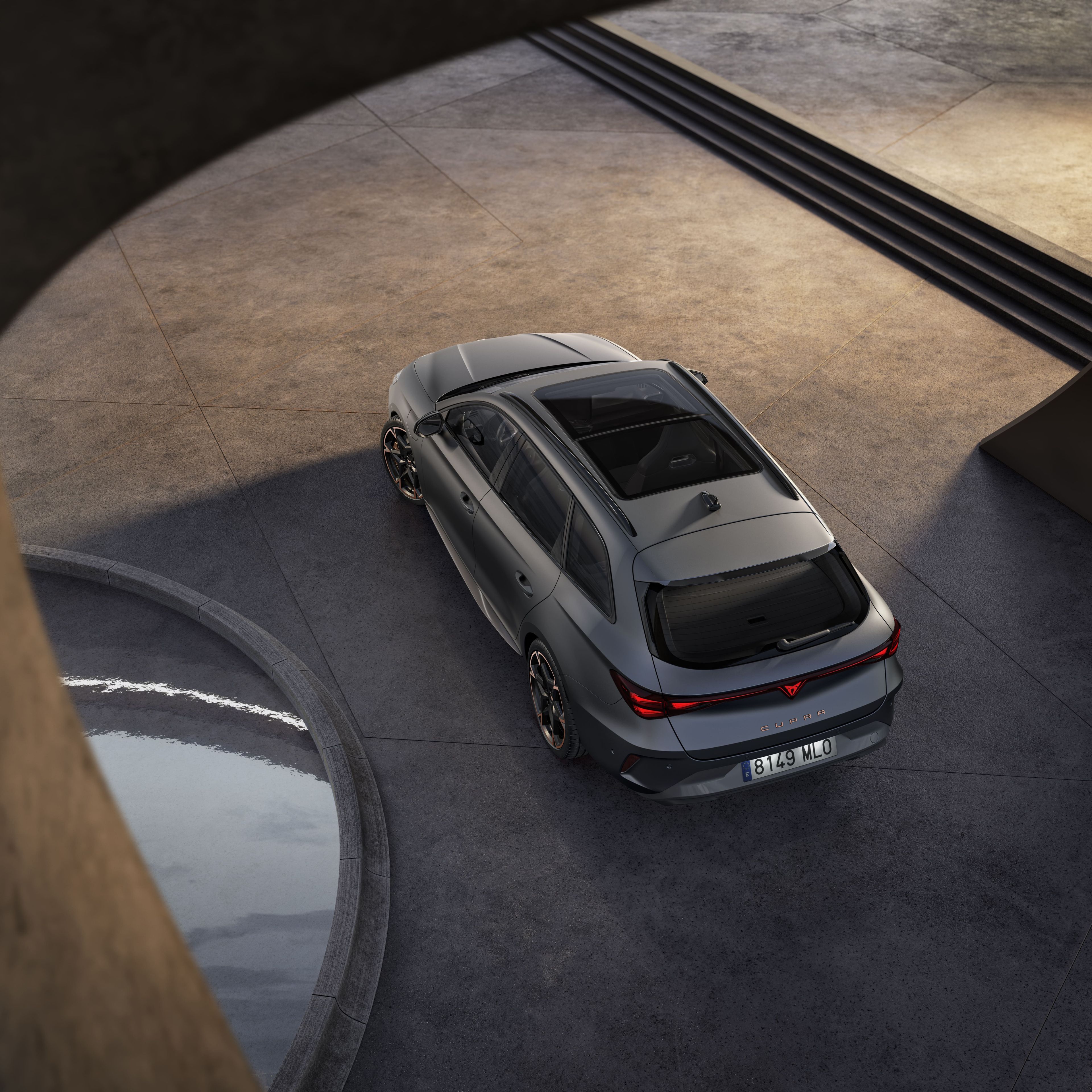 Vista aérea do novo Cupra leon sportstourer híbrido cinzento, para-choques traseiro, luzes traseiras acesas.