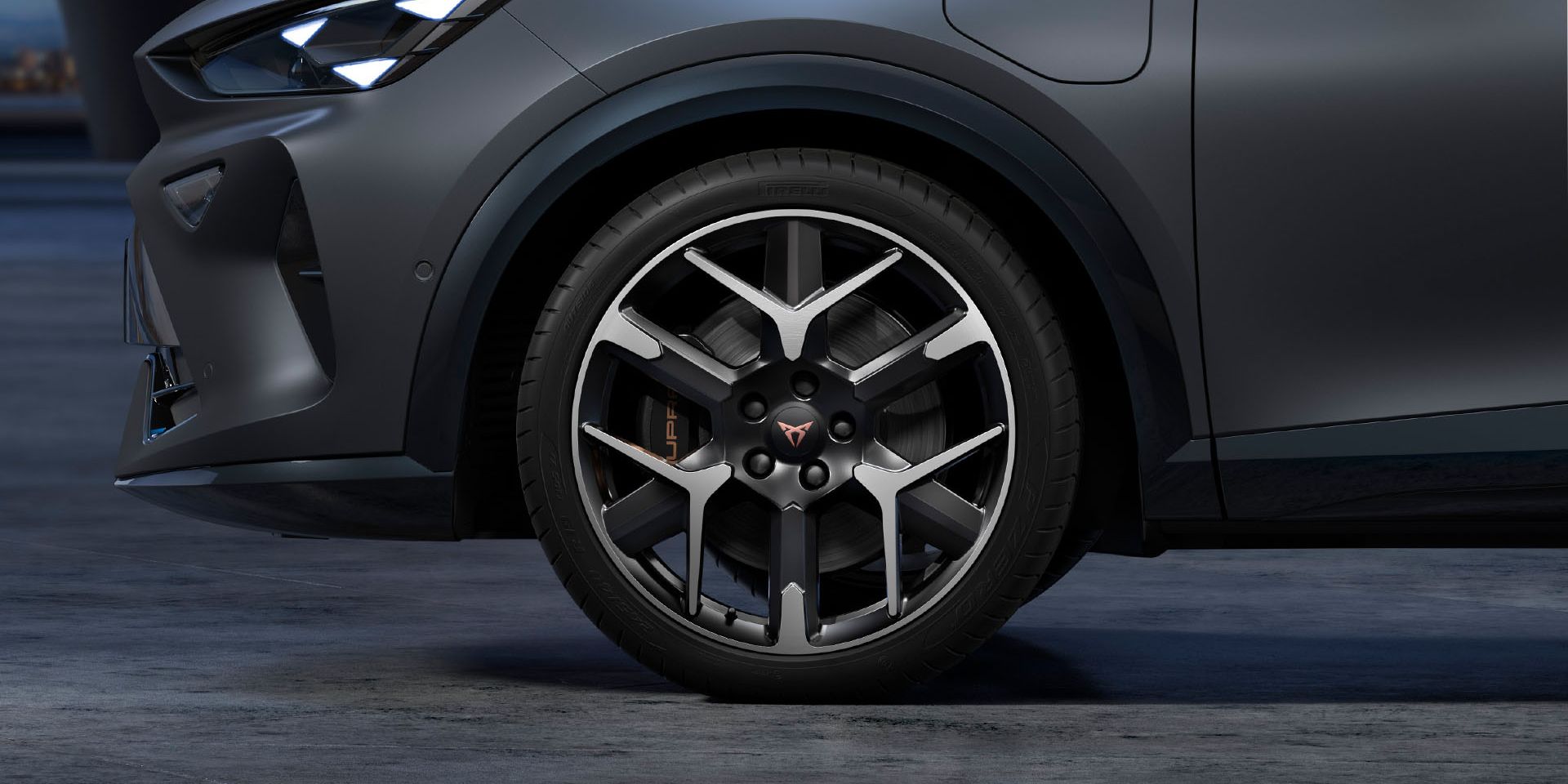 Vista frontal do CUPRA com jantes forjadas em prata e preto, pneus e faróis de assinatura.