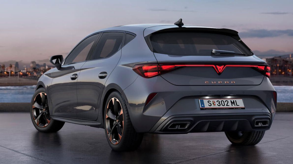 vista traseira do novo CUPRA Leon cinzento brilhante com controlo dinâmico do chassis e jantes de liga leve pretas e cobre. Cidade ao fundo ao pôr do sol