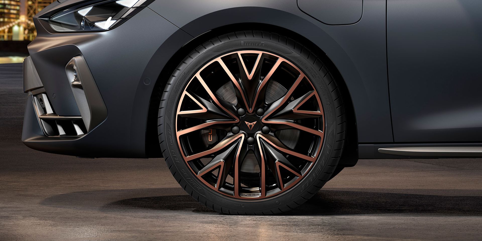 vista frontal das jantes mistral forjadas em cobre e preto para o novo cupra leon sportstourer, pneus, assinatura dos faróis e carroçaria cinzenta