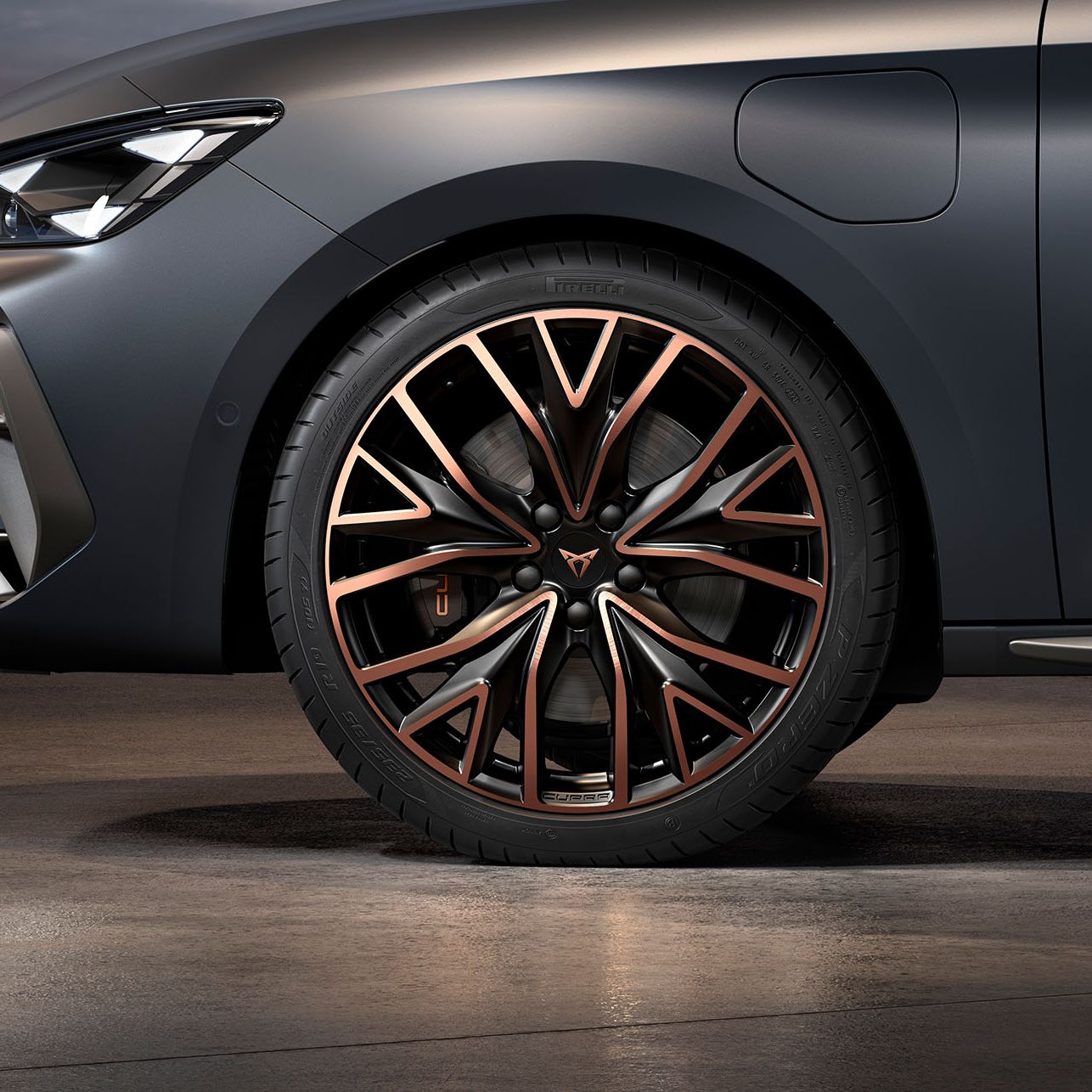 vista frontal das jantes mistral forjadas em cobre e preto para o novo cupra leon sportstourer, pneus, assinatura dos faróis e carroçaria cinzenta