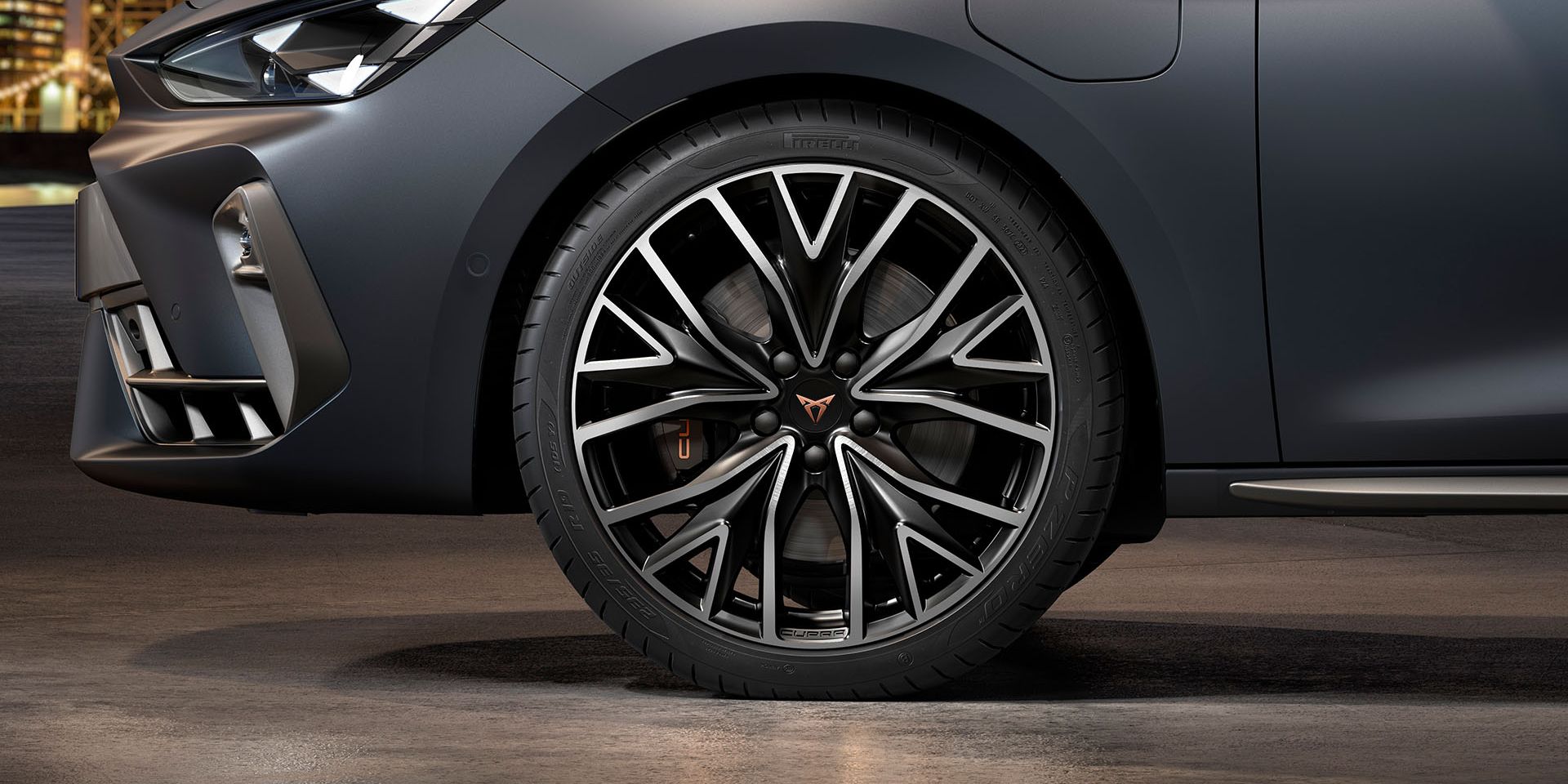 vista frontal das jantes de liga leve mistral maquinadas em prata e preto para o novo cupra leon sportstourer, pneus, assinatura dos faróis e carroçaria cinzenta