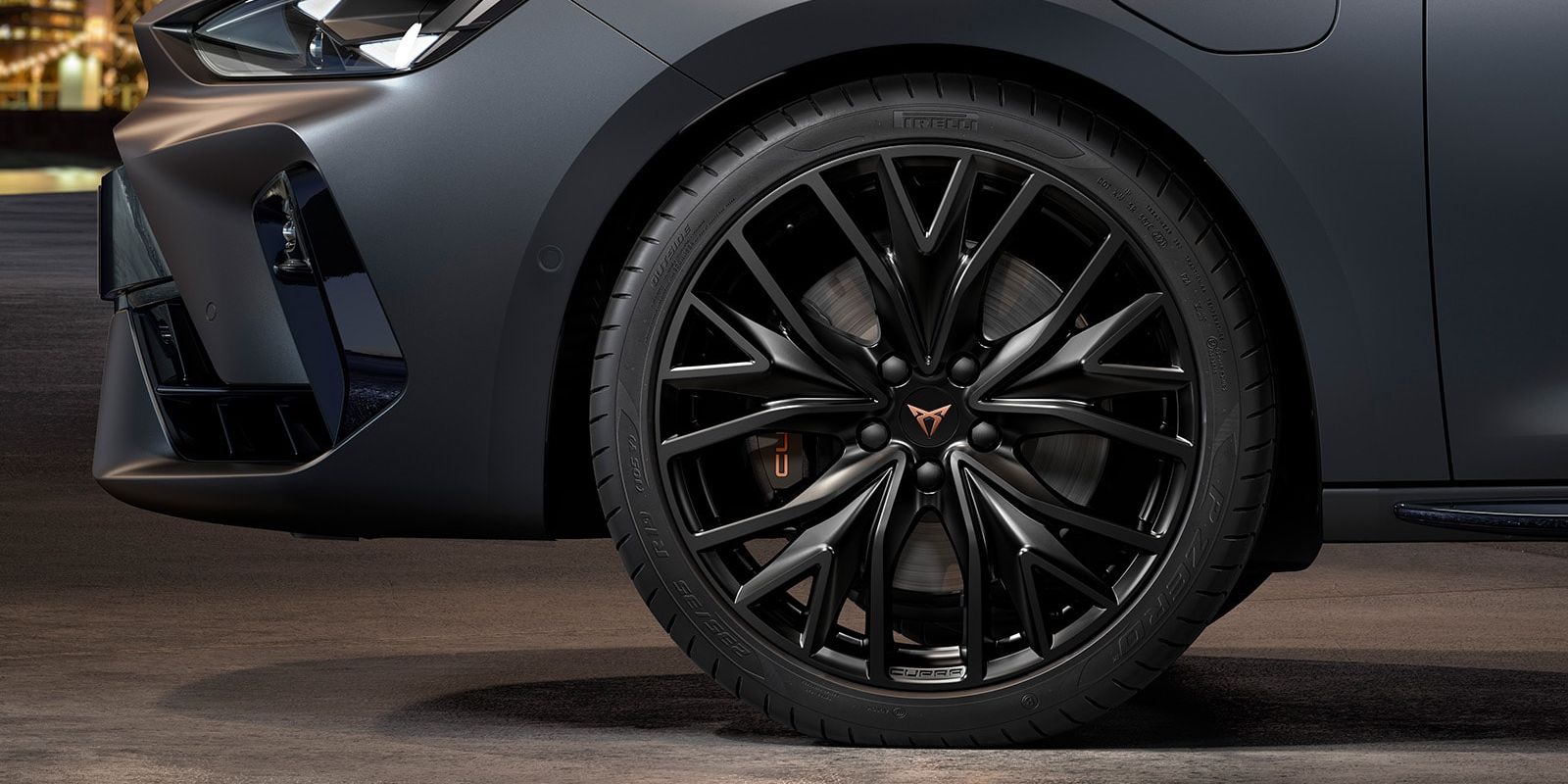 vista frontal das jantes de liga leve mistral maquinadas em preto para o novo CUPRA Leon Sportstourer, pneus, assinatura dos faróis e carroçaria cinzenta