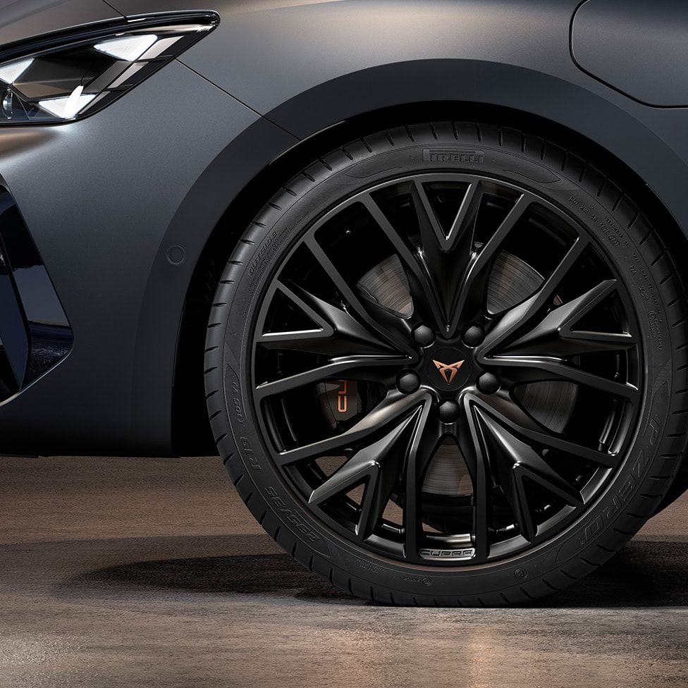 vista frontal das jantes de liga leve mistral maquinadas em preto para o novo CUPRA Leon Sportstourer, pneus, assinatura dos faróis e carroçaria cinzenta