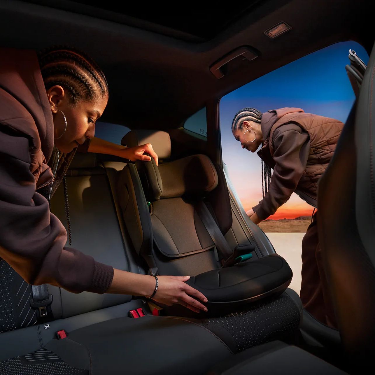 Interior do CUPRA Formentor com duas pessoas a colocar a cadeira de criança nos bancos traseiros