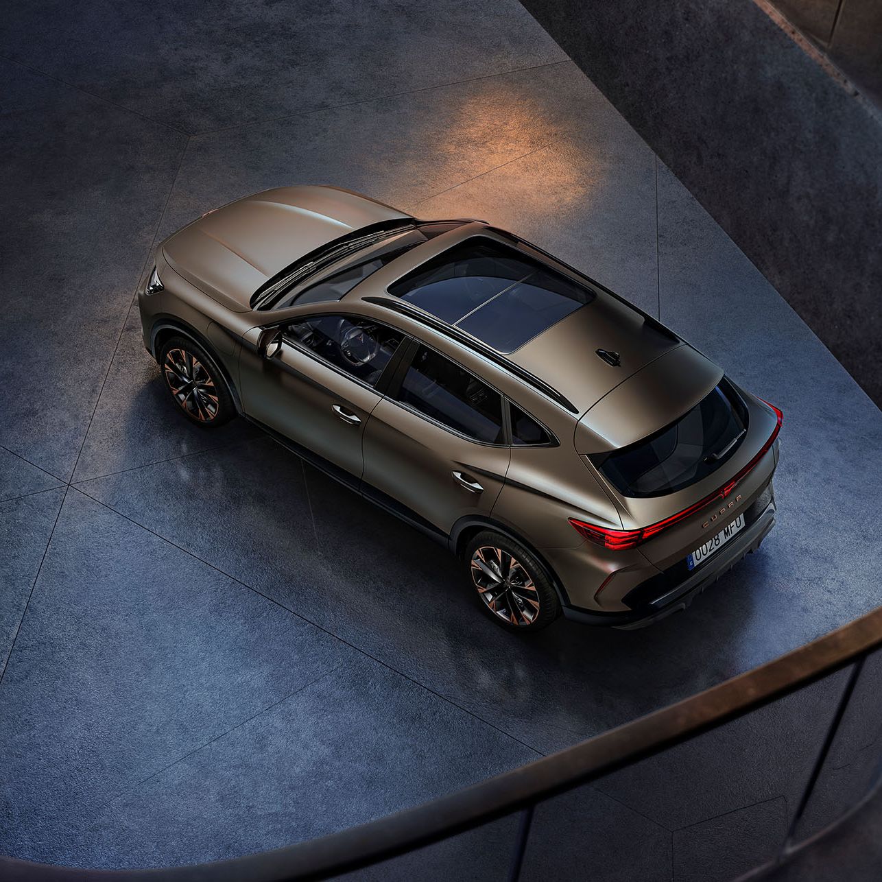 vista aérea do cupra formentor century bronze mate estacionado sobre cimento liso