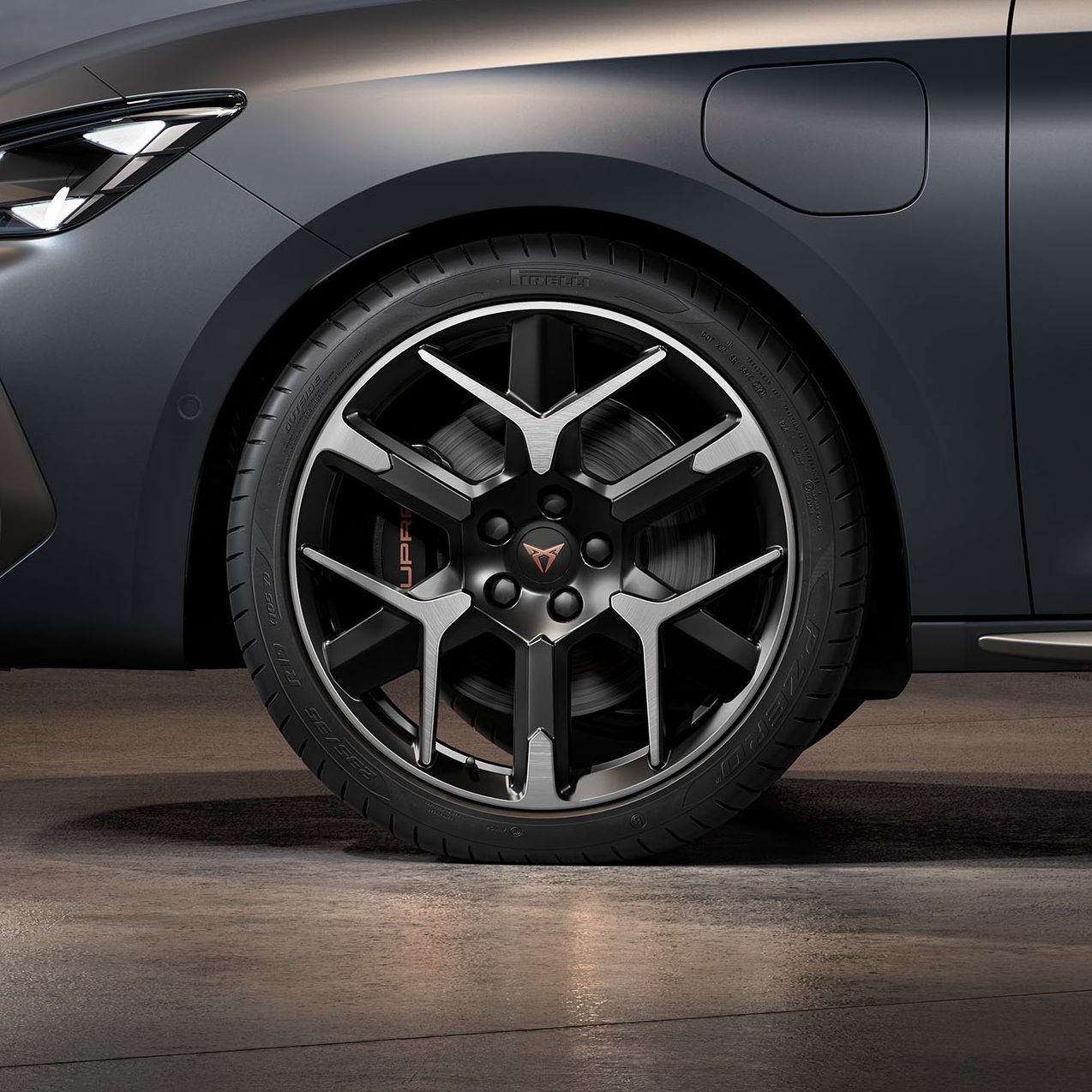 vista frontal das jantes de liga leve forjadas em prata e preto do novo CUPRA Leon, pneus, faróis de assinatura e carroçaria em cinzento mate