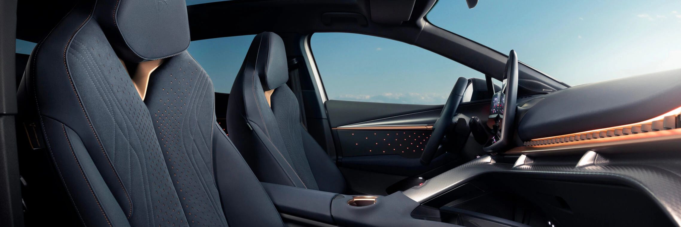 Bancos tipo bucket do CUPRA Tavascan com gravação em relevo e costuras em cobre, interior de viatura de empresa.