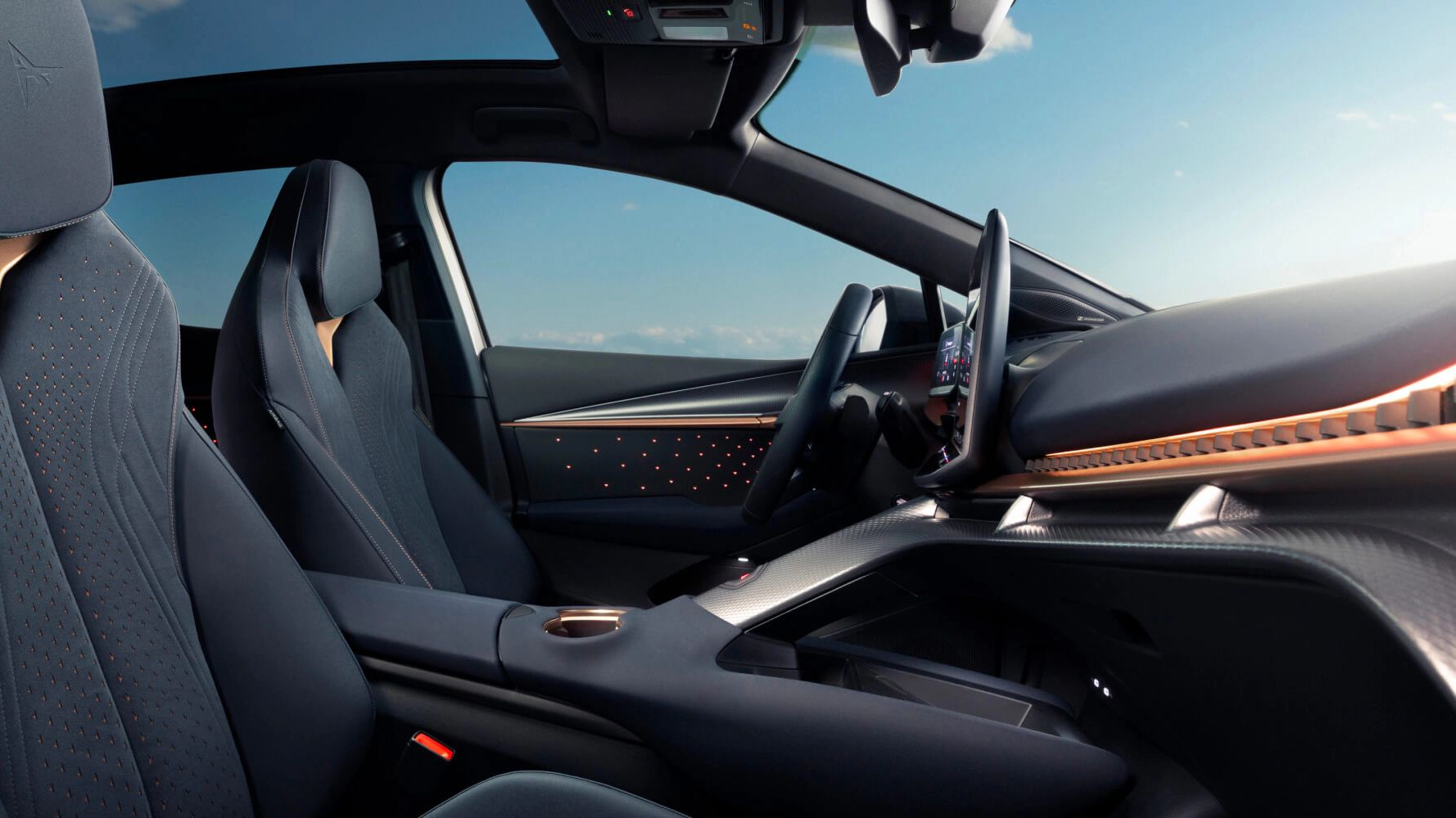 Vista traseira do CUPRA Tavascan cinzento, viatura de empresa, com jantes em cobre e luz contínua coast-to-coast.