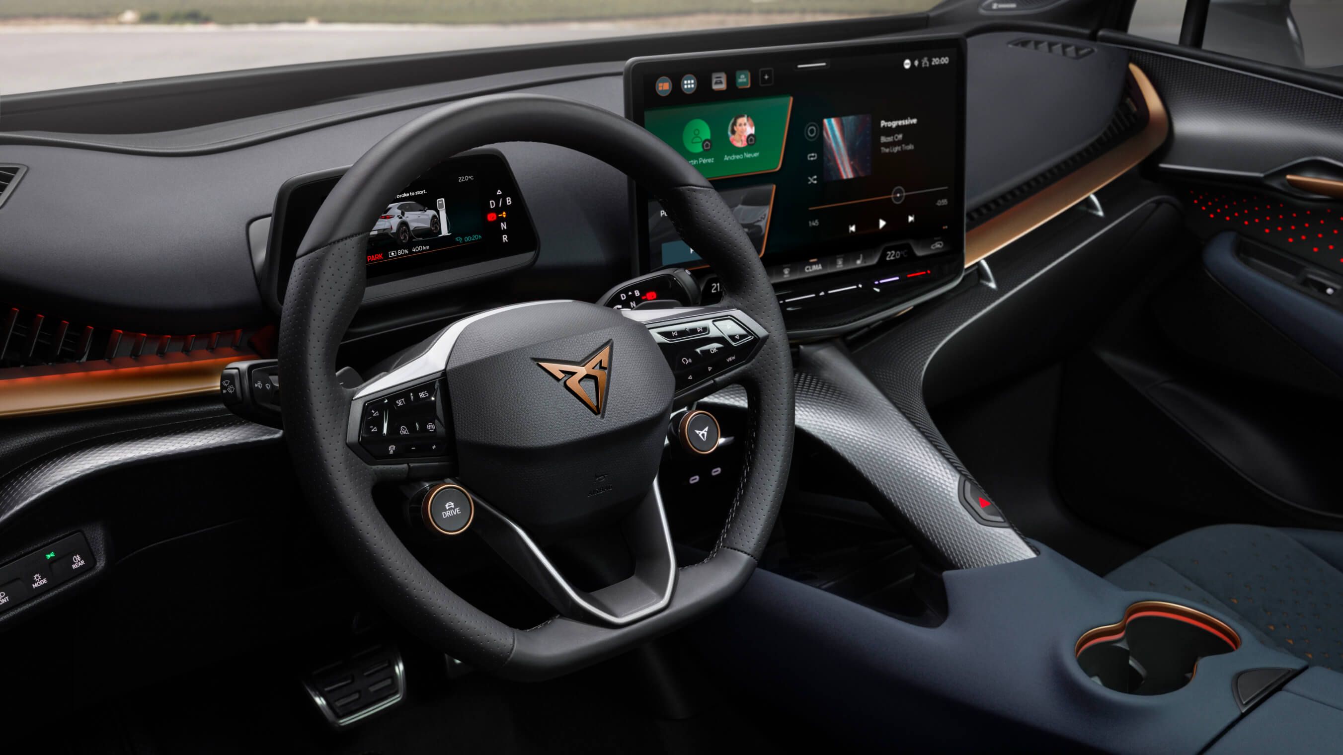 Cockpit do CUPRA Tavascan, com sistema de infotainment, porta-copos, volante, logótipo CUPRA em cobre e detalhes em cobre.