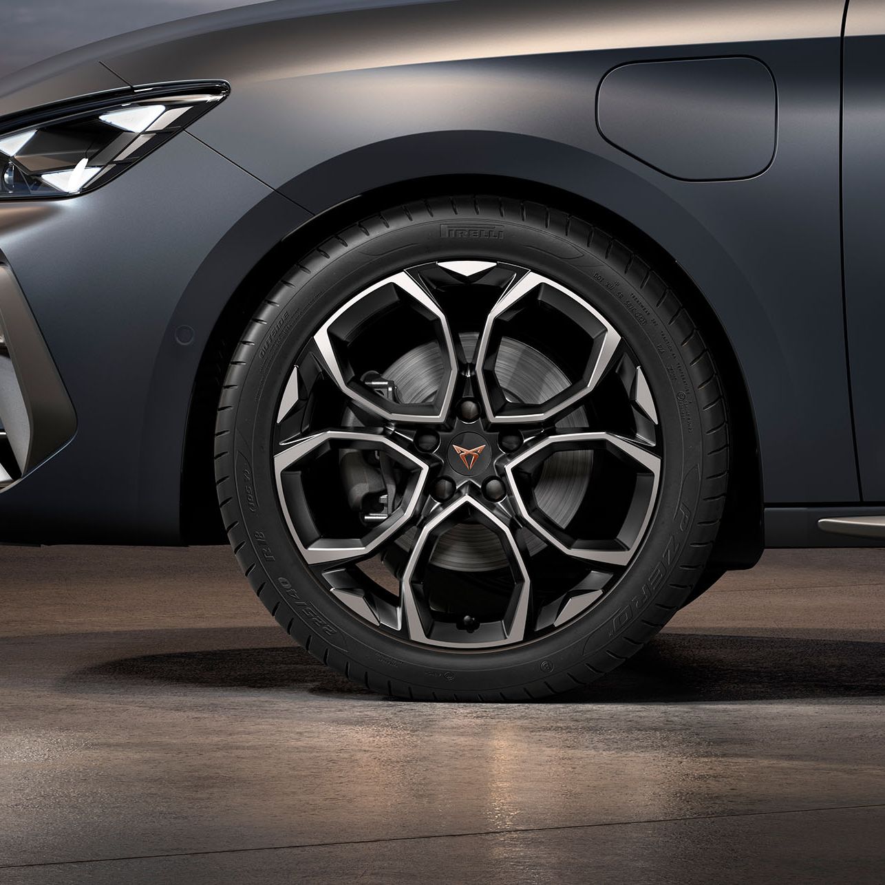 vista frontal da jante de liga leve Windstorm em prata maquinada e preto para o novo cupra leon sportstourer, pneus, assinatura dos faróis e carroçaria cinzenta
