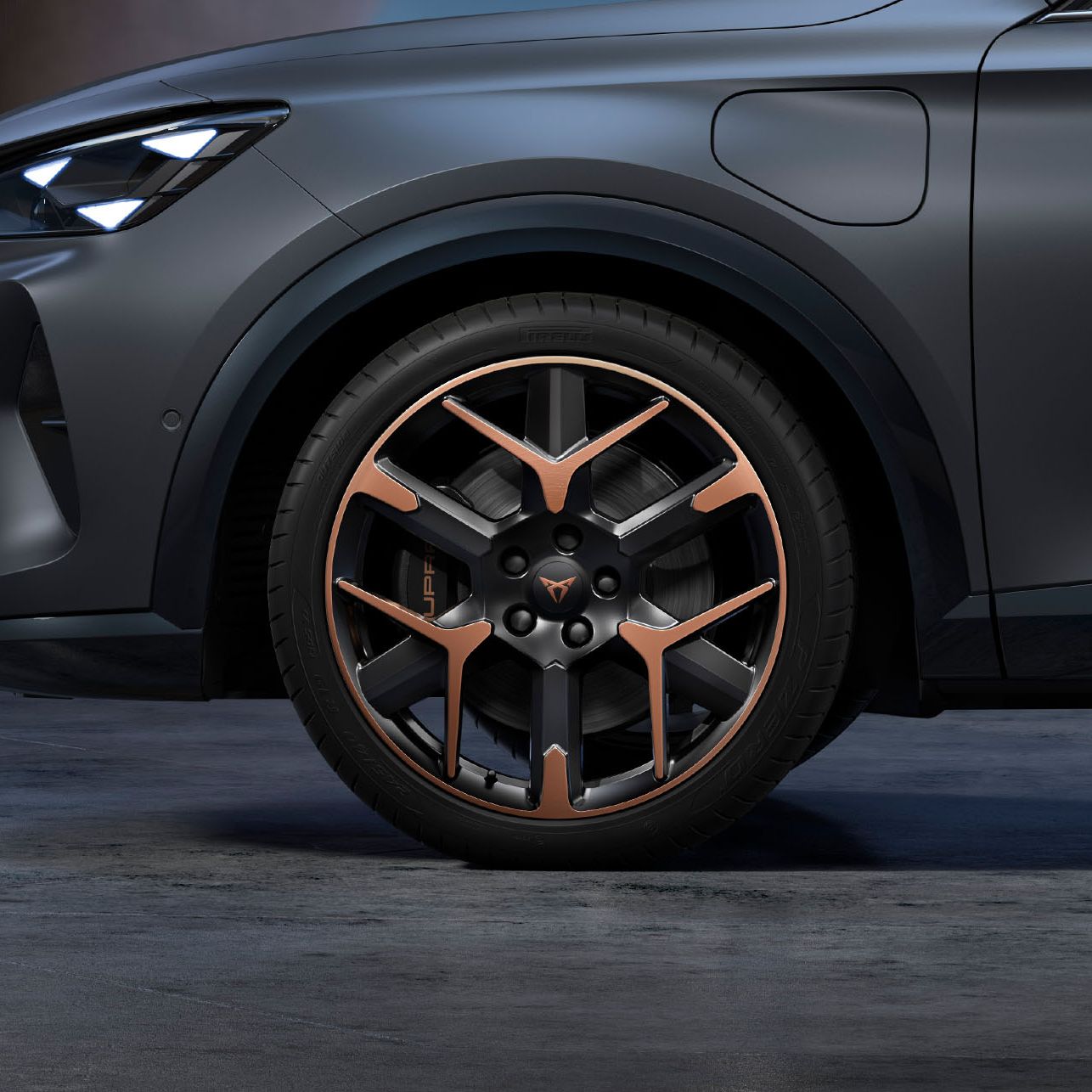 Vista frontal lateral das jantes de 19” forjadas em cobre e preto, pneus e faróis de assinatura