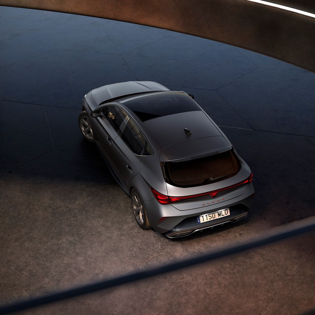 Vista frontal do novo CUPRA Leon em ambiente escuro, com iluminação ambiente.